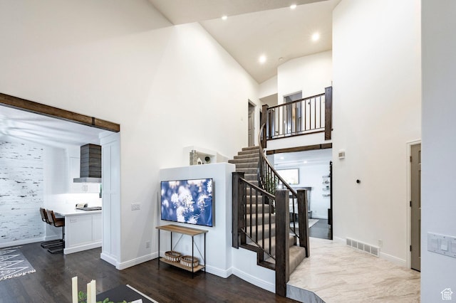 stairs with high vaulted ceiling, wood finished floors, baseboards, and recessed lighting