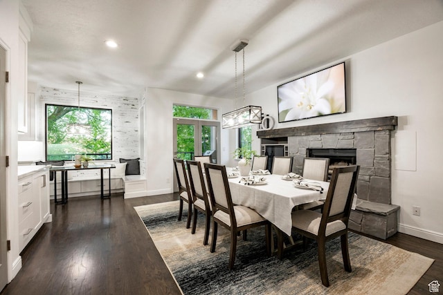 dining space featuring healthy amount of natural light, a chandelier, baseboards, a fireplace, and recessed lighting