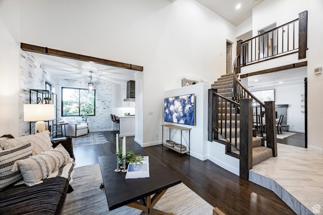 living room with wood finished floors, a high ceiling, stairway, and baseboards