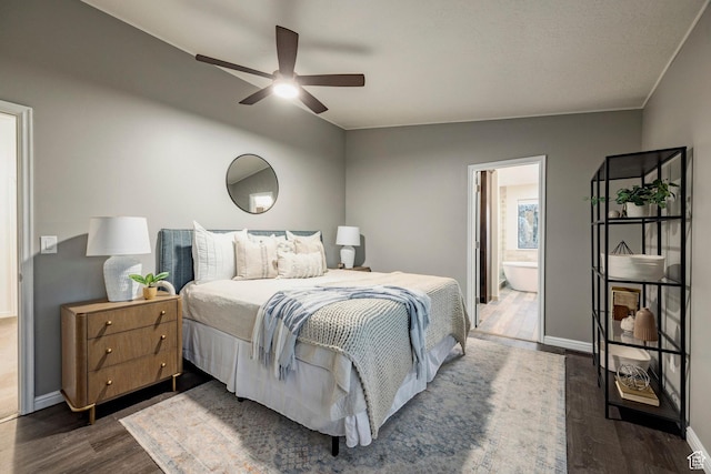 bedroom with dark wood finished floors, baseboards, ensuite bathroom, and a ceiling fan