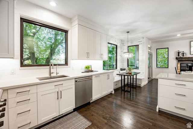 kitchen with dishwasher, a sink, light countertops, white cabinets, and recessed lighting