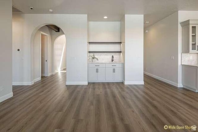 3208 S Sand Stone Dr, Hurricane, UT 84737 - unfurnished living room featuring arched walkways, wood finished floors, baseboards, and recessed lighting