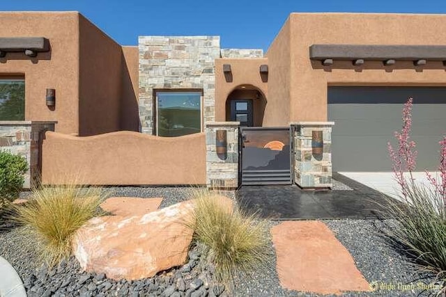 3208 S Sand Stone Dr, Hurricane, UT 84737 - pueblo-style house with a gate, stucco siding, and a fenced front yard