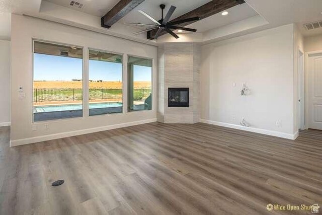 3208 S Sand Stone Dr, Hurricane, UT 84737 - unfurnished living room featuring a ceiling fan, wood finished floors, baseboards, beamed ceiling, and a tiled fireplace