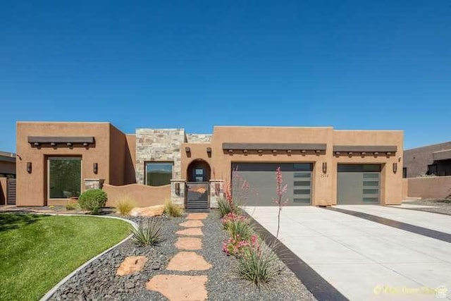 3208 S Sand Stone Dr, Hurricane, UT 84737 - southwest-style home with a garage, concrete driveway, a gate, and stucco siding