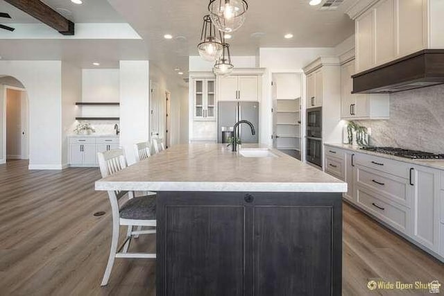 3208 S Sand Stone Dr, Hurricane, UT 84737 - kitchen with arched walkways, gas cooktop, stainless steel fridge, wood finished floors, and recessed lighting