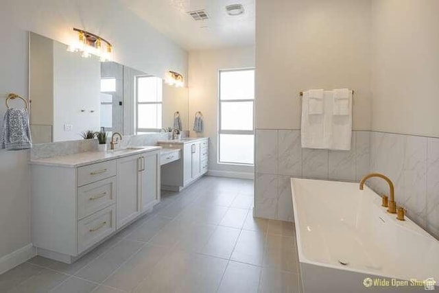 3208 S Sand Stone Dr, Hurricane, UT 84737 - bathroom featuring a soaking tub, vanity, tile patterned flooring, a wainscoted wall, and tile walls