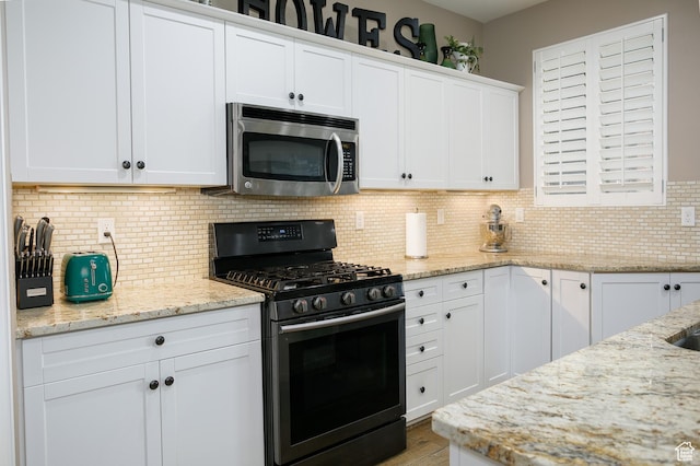 161 S 2775 W, West Point, UT 84015 - kitchen featuring appliances with stainless steel finishes, white cabinets, backsplash, light stone countertops, and wood finished floors