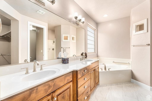 8 S Arroyo Dr, St George, UT 84790 - bathroom featuring a garden tub, double vanity, marble finish flooring, baseboards, and a walk in closet