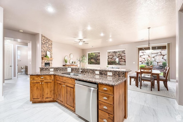 8 S Arroyo Dr, St George, UT 84790 - kitchen with a sink, stainless steel dishwasher, light marble finish floors, brown cabinetry, and a stone fireplace