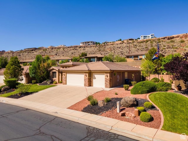 8 S Arroyo Dr, St George, UT 84790 - view of front of house with a garage, concrete driveway, stucco siding, a tiled roof, and stone siding