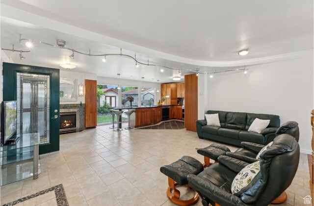 635 E Pioneer Ave S, Sandy, UT 84070 - living area with track lighting, light tile patterned floors, and a warm lit fireplace