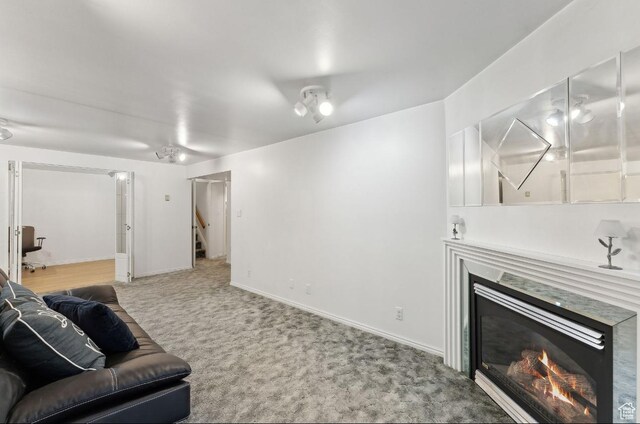 635 E Pioneer Ave S, Sandy, UT 84070 - living room with a glass covered fireplace, carpet flooring, stairway, and baseboards
