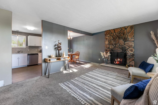 living area with carpet, a fireplace, and a textured ceiling