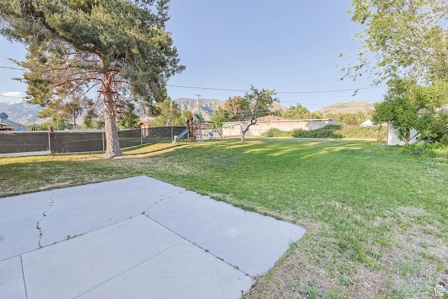 view of yard featuring a playground and a patio area