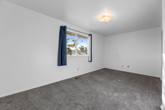 empty room featuring carpet flooring and baseboards
