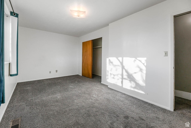unfurnished bedroom featuring carpet, baseboards, and a closet