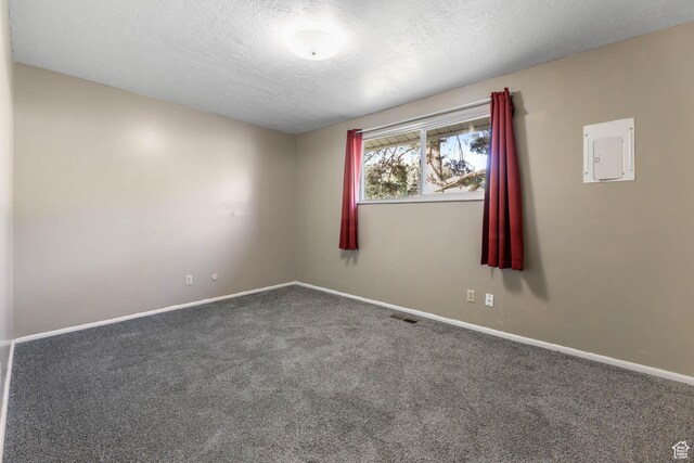 carpeted empty room with baseboards and a textured ceiling
