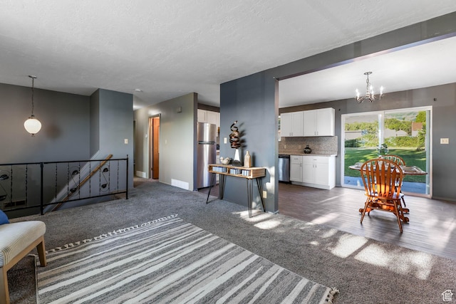 sitting room featuring carpet flooring, a chandelier, an upstairs landing, a textured ceiling, and baseboards