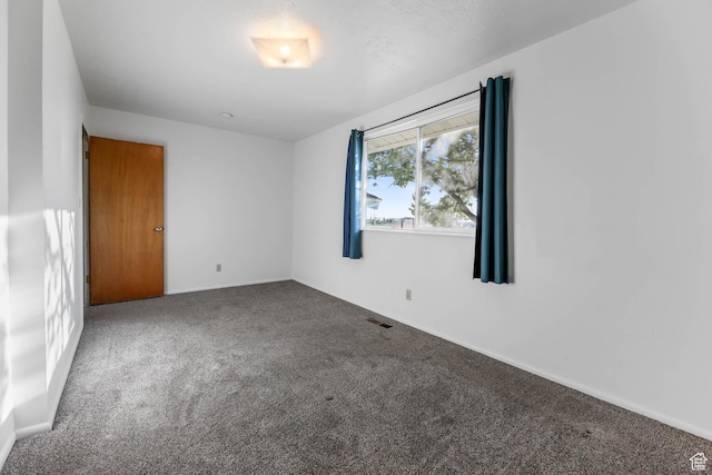 carpeted empty room with baseboards