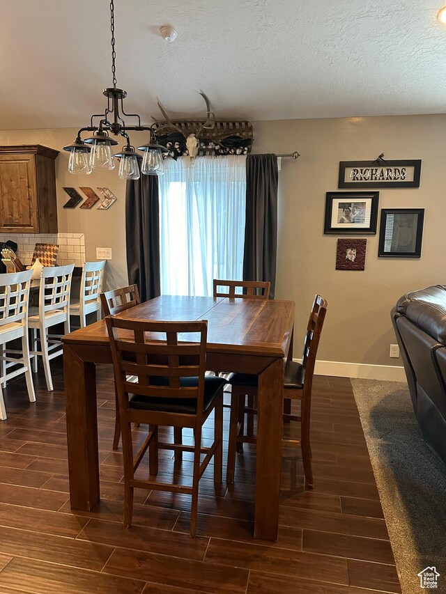 1783 E 2000 S, Naples, UT 84078 - dining area featuring dark wood-type flooring, a textured ceiling, a chandelier, and baseboards