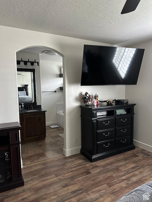 1783 E 2000 S, Naples, UT 84078 - bedroom featuring a textured ceiling, dark wood-style flooring, a sink, baseboards, and arched walkways