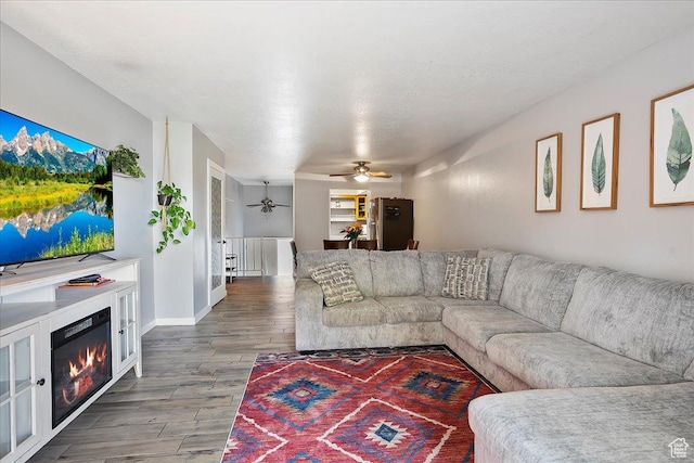 5667 S Aspen Ct E, South Ogden, UT 84403 - living area with a ceiling fan, wood finished floors, a glass covered fireplace, and baseboards