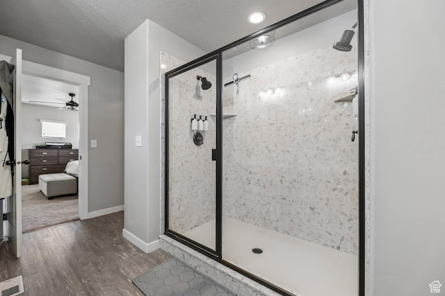 7886 N Bridleway Rd, Eagle Mountain, UT 84005 - ensuite bathroom featuring wood finished floors, a stall shower, baseboards, ceiling fan, and a textured ceiling