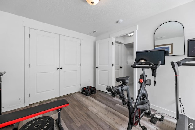 7886 N Bridleway Rd, Eagle Mountain, UT 84005 - exercise room with wood finished floors and a textured ceiling