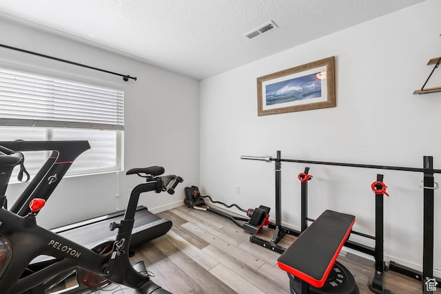7886 N Bridleway Rd, Eagle Mountain, UT 84005 - exercise room with wood finished floors, a textured ceiling, and baseboards