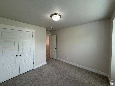 6396 W Sugarcane Dr W Unit 345, South Jordan, UT 84009 - unfurnished bedroom with carpet flooring, baseboards, and a closet