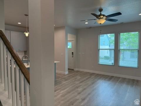 6396 W Sugarcane Dr W Unit 345, South Jordan, UT 84009 - unfurnished living room with baseboards, light wood-type flooring, ceiling fan, and recessed lighting