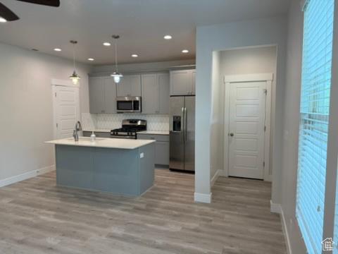 6396 W Sugarcane Dr W Unit 345, South Jordan, UT 84009 - kitchen featuring appliances with stainless steel finishes, ceiling fan, gray cabinets, baseboards, and decorative backsplash