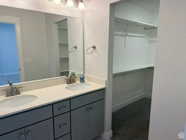 6396 W Sugarcane Dr W Unit 345, South Jordan, UT 84009 - full bathroom with double vanity, a spacious closet, and baseboards