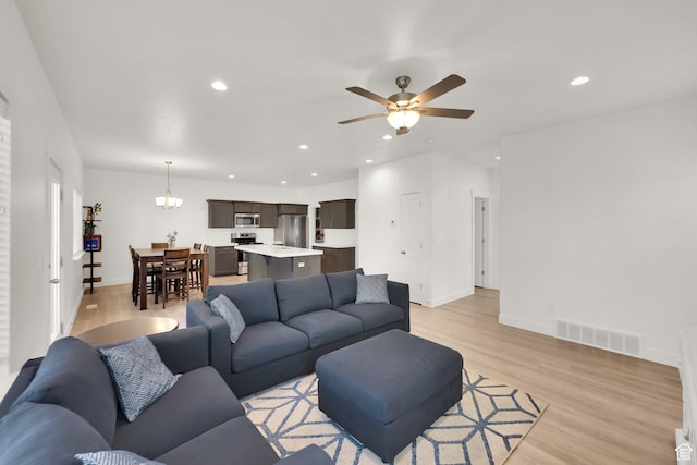 7208 N Silver Spring Way, Eagle Mountain, UT 84005 - living room featuring light wood finished floors, ceiling fan, baseboards, recessed lighting, and a chandelier