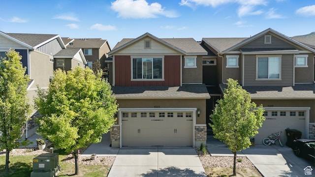 5213 W Courtly Ln, Herriman, UT 84096 - view of front of property with an attached garage, driveway, stone siding, and board and batten siding