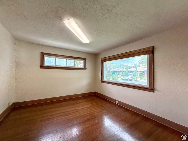 1980 S 600 E, Salt Lake City, UT 84105 - unfurnished room with wood finished floors, plenty of natural light, baseboards, and a textured ceiling