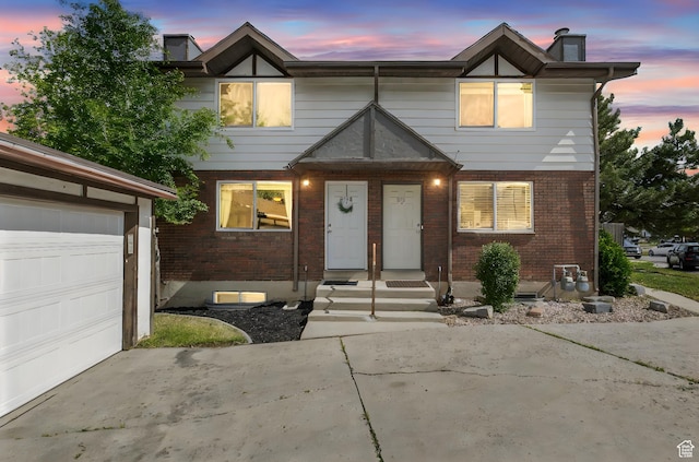 8316 S Carmen Ct E, Sandy, UT 84070 - townhome / multi-family property featuring brick siding, a chimney, concrete driveway, and a garage