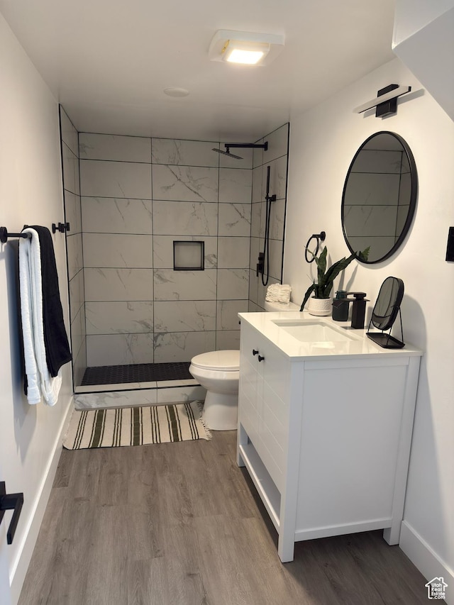 4868 W Seneca Rd S, West Valley City, UT 84120 - full bathroom featuring wood finished floors, toilet, vanity, and a tile shower