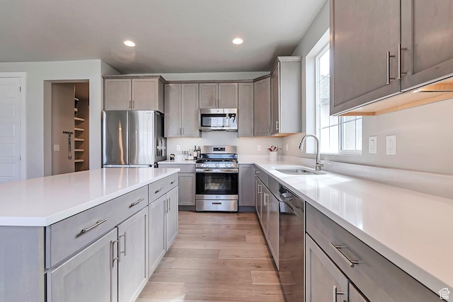3864 W Safflower Dr, Lehi, UT 84043 - kitchen with appliances with stainless steel finishes, a sink, light wood-style floors, gray cabinetry, and recessed lighting