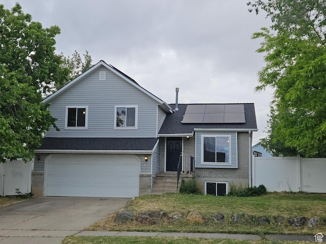 417 W 225 N, Clearfield, UT 84015 - tri-level home with an attached garage, roof mounted solar panels, concrete driveway, and a shingled roof