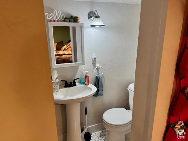 64 S 300 E, Preston, ID 83263 - bathroom featuring toilet, baseboards, and a sink