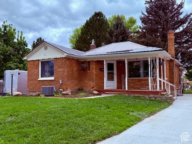 64 S 300 E, Preston, ID 83263 - view of front facade featuring a chimney, a porch, central air condition unit, and a front lawn
