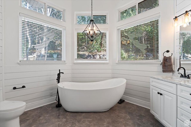 14771 S Brewster Dr, Draper, UT 84020 - bathroom featuring a chandelier, vanity, a freestanding tub, toilet, and wood walls