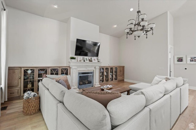 14771 S Brewster Dr, Draper, UT 84020 - living area with lofted ceiling, a chandelier, light wood finished floors, a glass covered fireplace, and recessed lighting