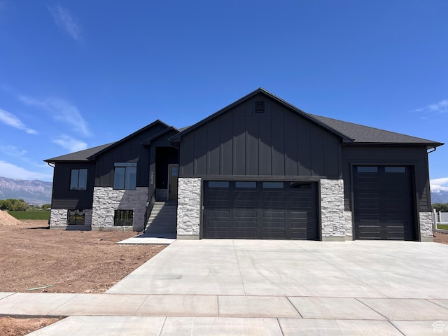 1234 N 4925 W, Plain City, UT 84404 - view of front facade with board and batten siding, an attached garage, stone siding, and concrete driveway