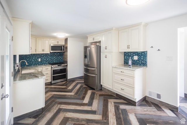 595 W Winchester St, Murray, UT 84123 - kitchen with stainless steel appliances, a sink, backsplash, and cream cabinets
