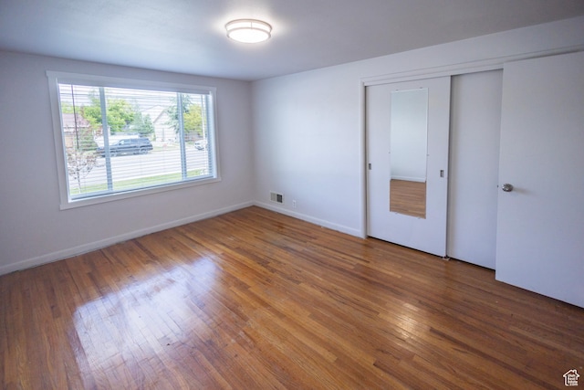595 W Winchester St, Murray, UT 84123 - unfurnished bedroom featuring wood finished floors, a closet, and baseboards