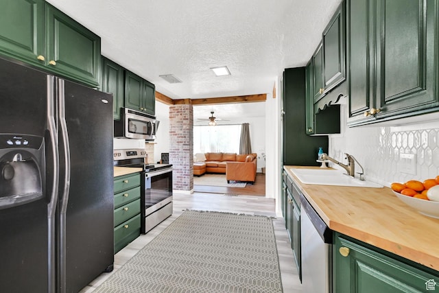 2890 Wheelock Ave, Ogden, UT 84403 - kitchen featuring stainless steel appliances, green cabinetry, a sink, wood counters, and ceiling fan