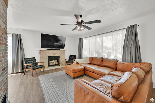 2890 Wheelock Ave, Ogden, UT 84403 - living room featuring a fireplace, a ceiling fan, plenty of natural light, a textured ceiling, and light wood-style floors